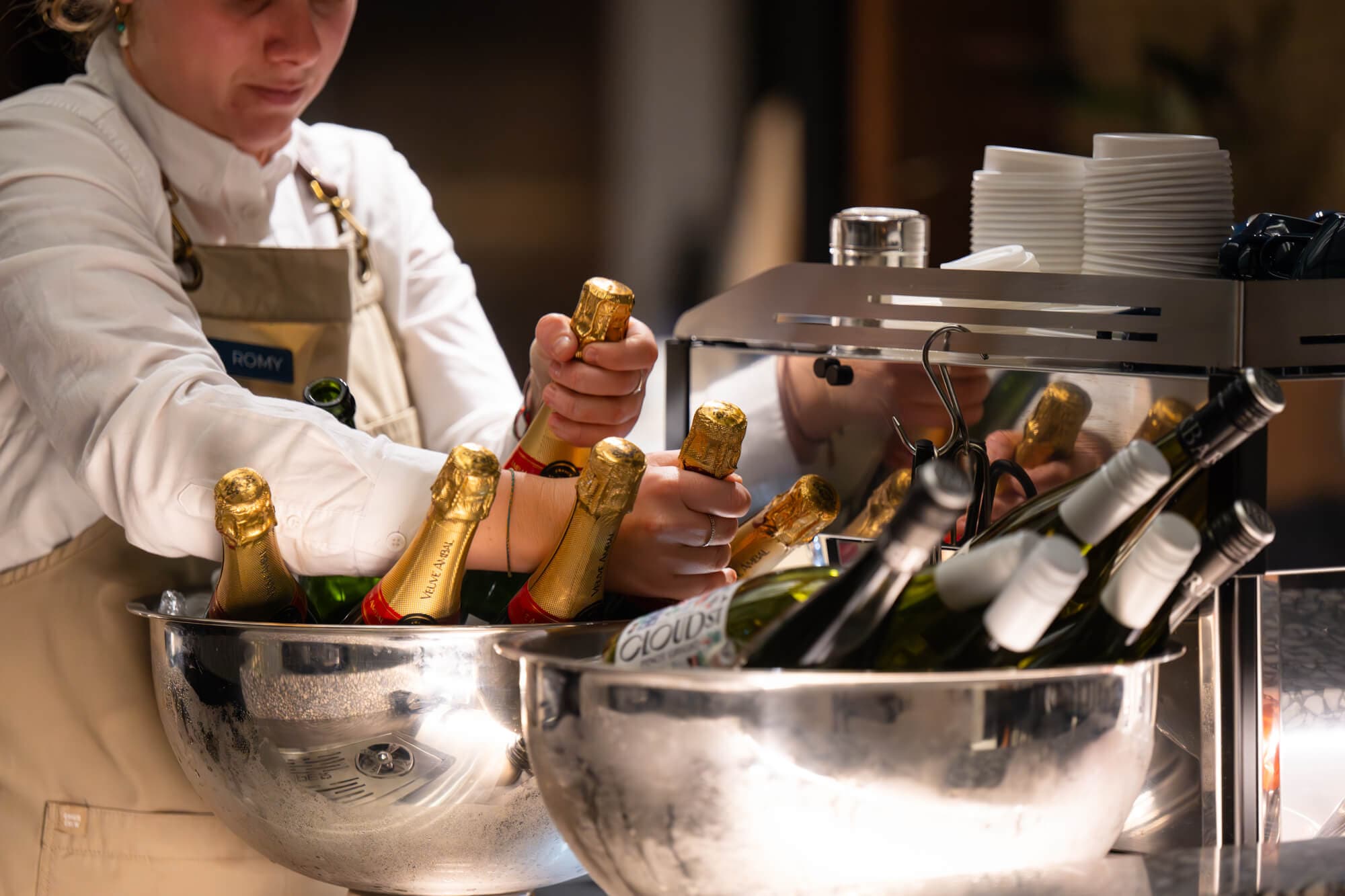 Champagne bottles being lifted from silver ice bowls at the 2025 gala